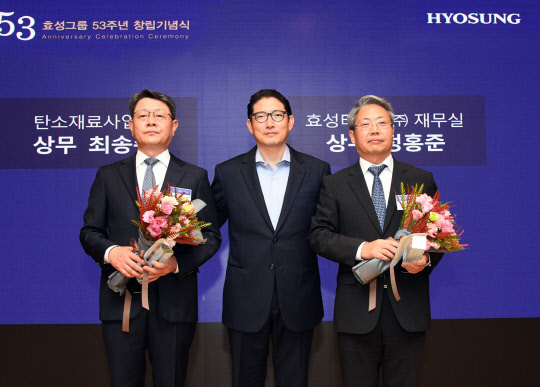 조현준(가운데) 효성 회장이 1일 창립 53주년을 맞아 서울 마포 본사에서 열린 창립기념식에서 30년 장기근속상을 수상한 최송주(왼쪽) 효성첨단소재 상무, 정홍준 효성티앤씨 상무와 기념촬영을하고 있다. <효성 제공>